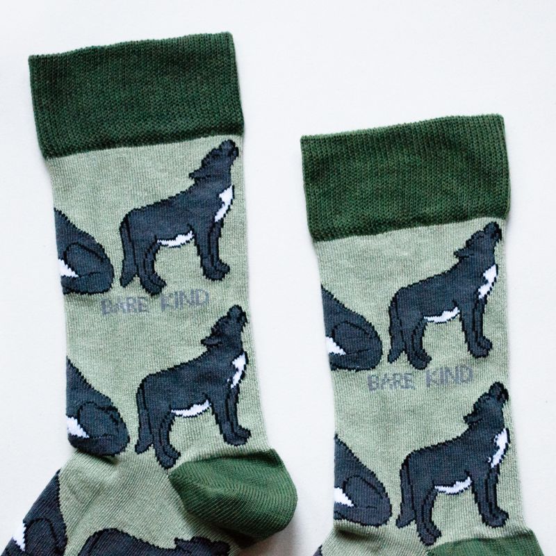 Pair of socks with wolf design and 'Barefoot Kind' text on a light background