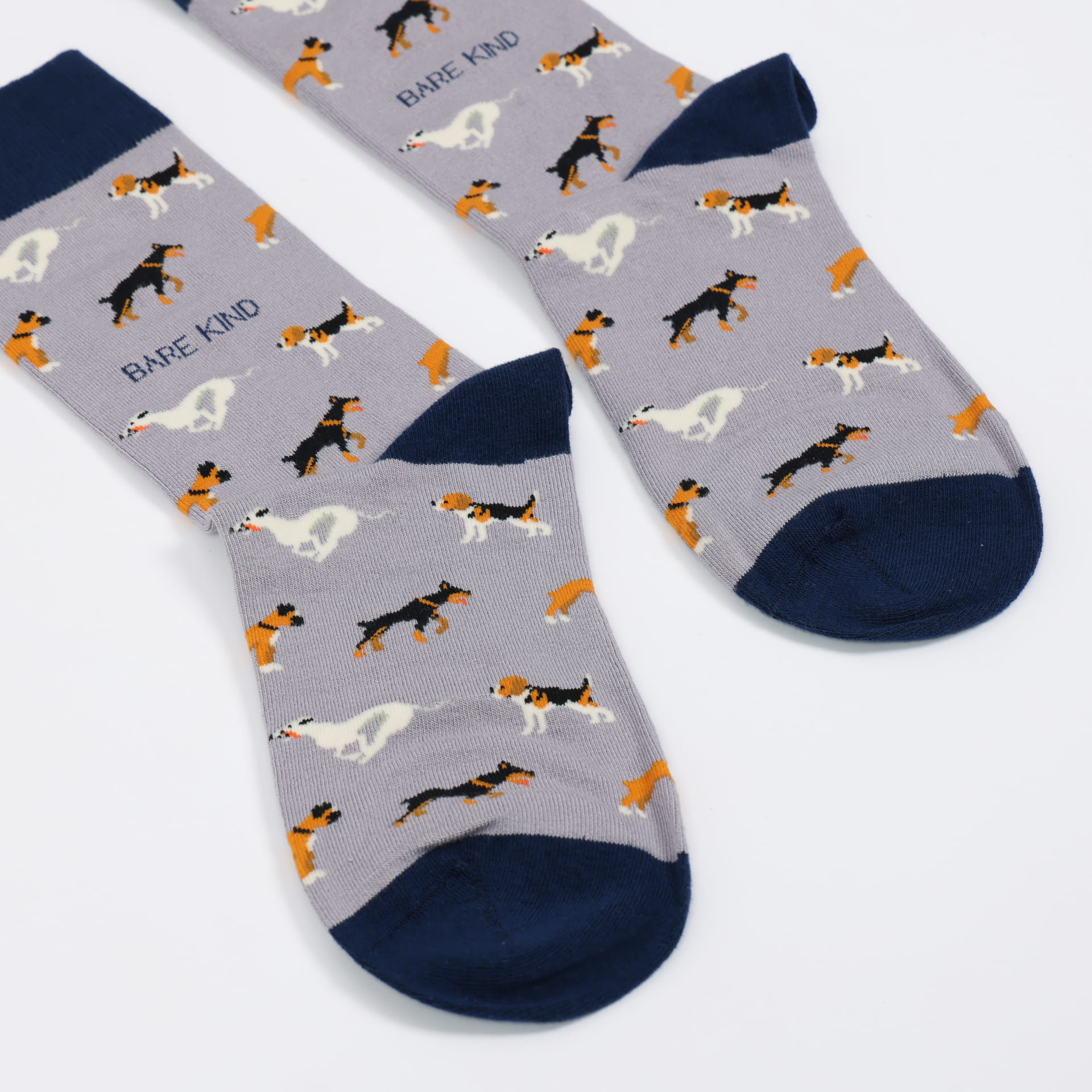 Pair of socks with dog pattern and 'Bare Kind' branding on a light gray background