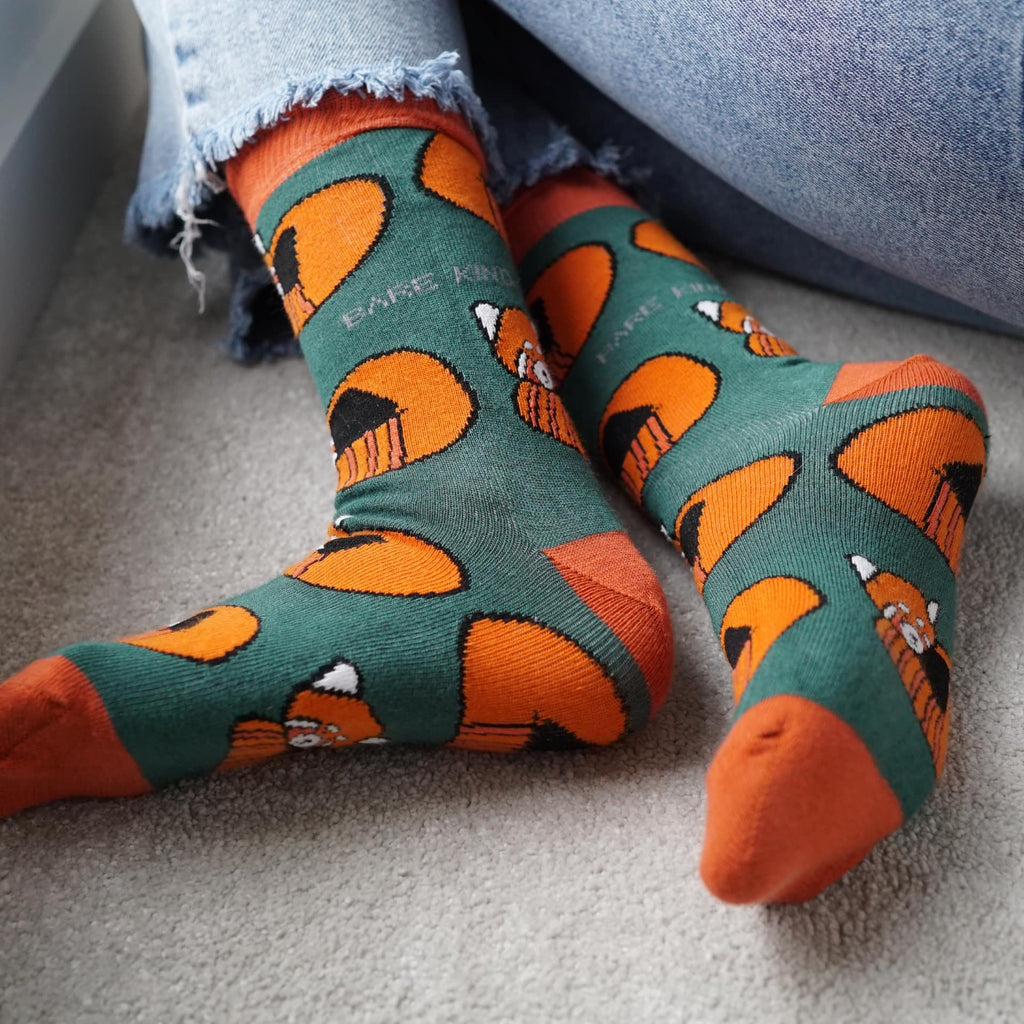 Person wearing socks with fox pattern on a carpeted floor