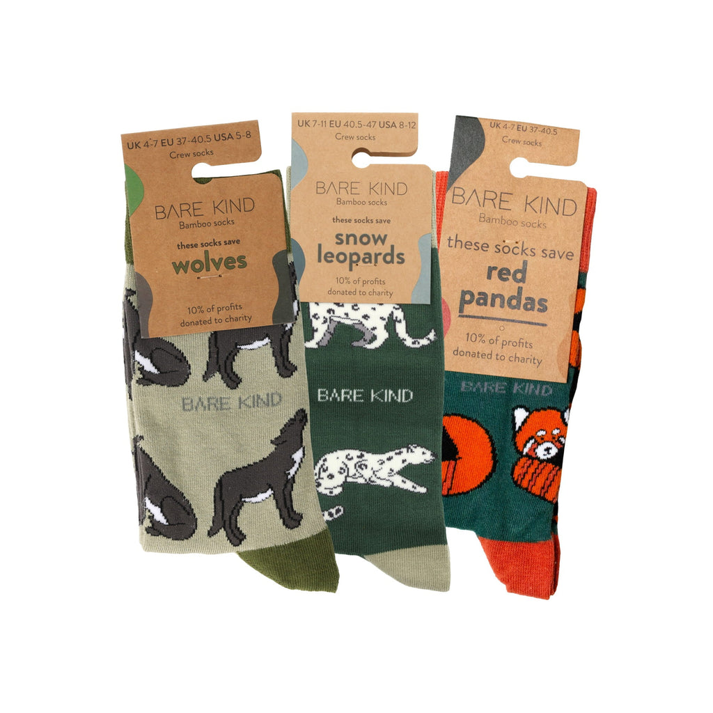 Three pairs of socks with animal-themed packaging and labels, featuring wolves, snow leopards, and red pandas.